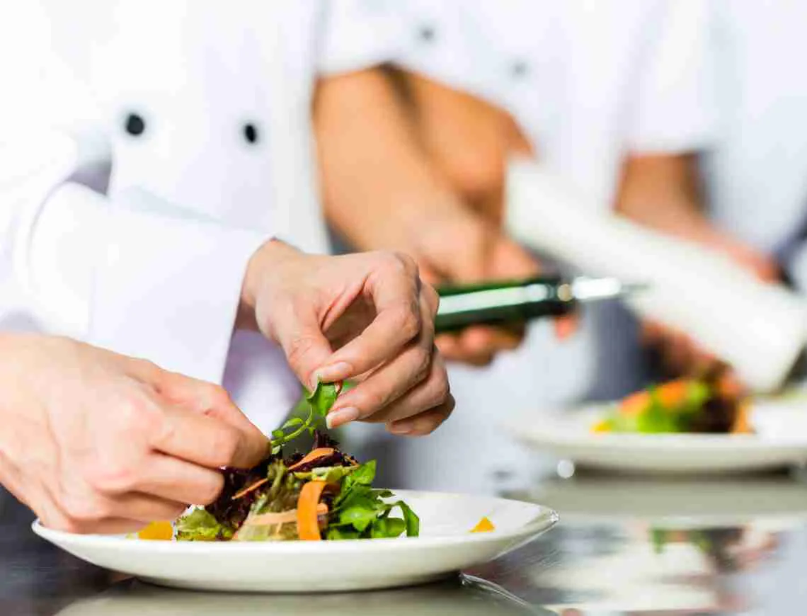 Chef putting garnish on a plate - 799x610