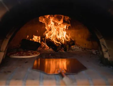 Pizza being cooked in woodfire oven