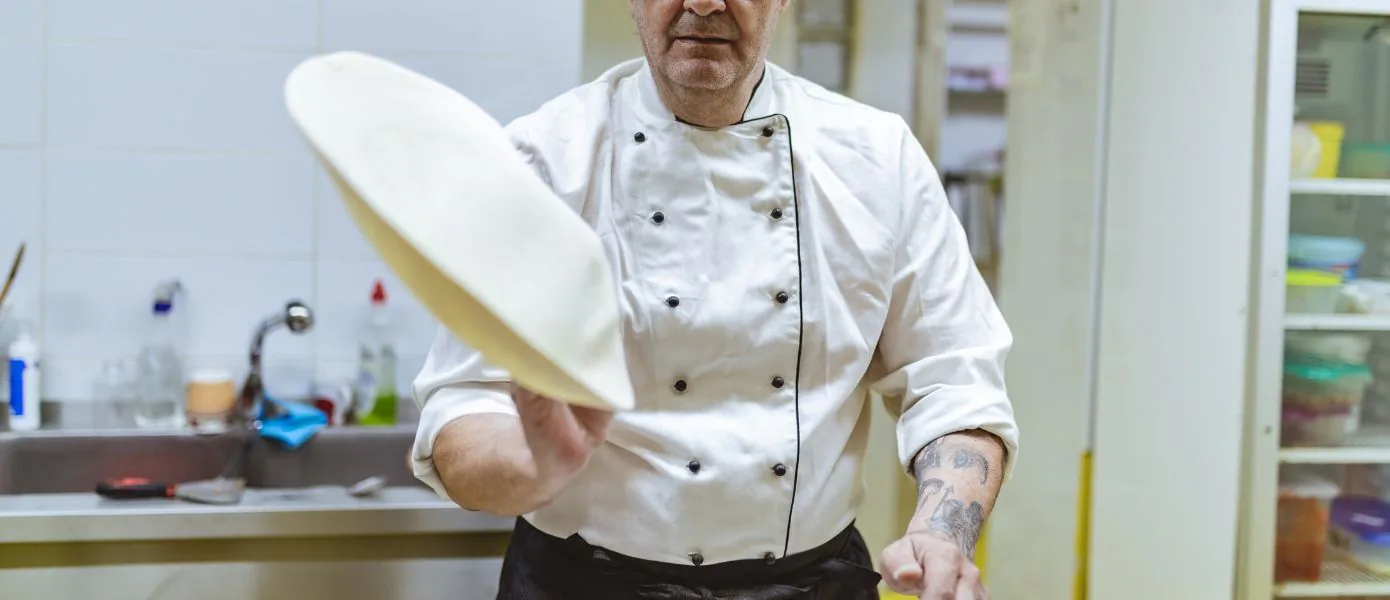 Pizza Chef performing pizza acrobatics