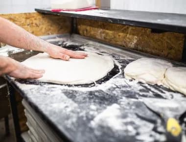 Person opening the pizza dough